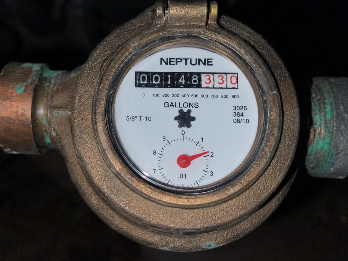 A sharp close-up of the meter face, framed too tight for the pipe run
